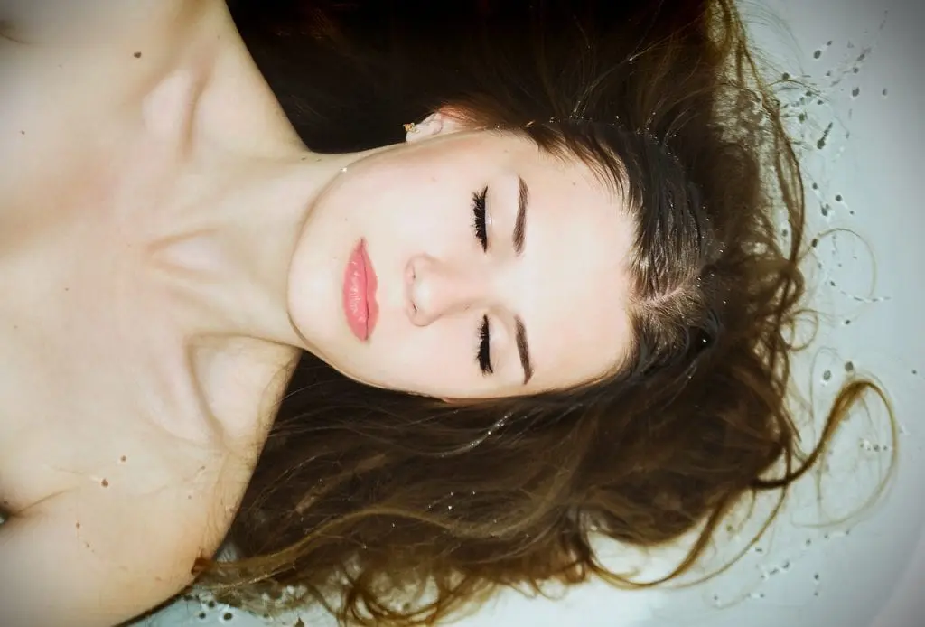 kobieta z mokrymi włosami w wannie