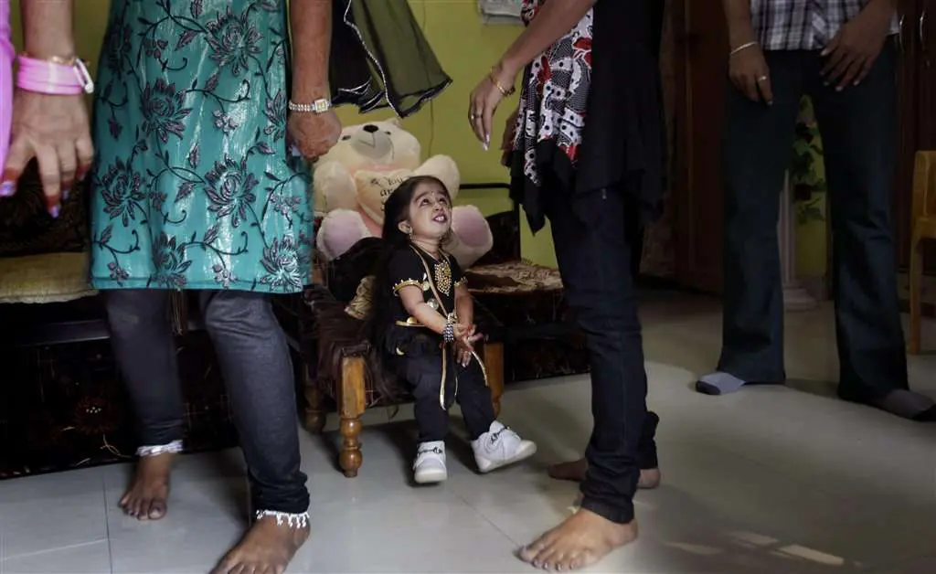 Jyoti Amge w otoczeniu ludzi o standardowym wzroście. 