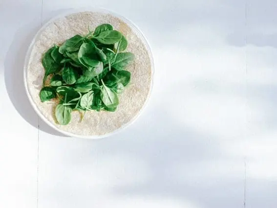 10 niesamowitych właściwości szpinaku Tortilla ze szpinakiem na talerzu.