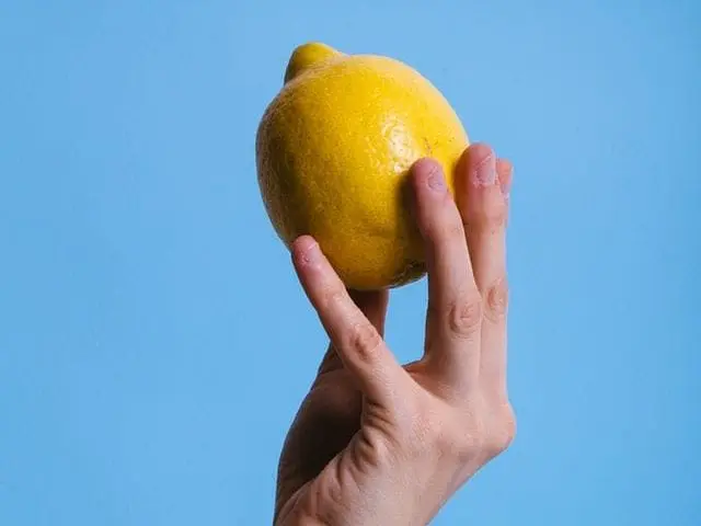 Kobieta kroi cytrynę i kładzie ją obok łóżka. Powód? Każdy powinien to wypróbować Dłoń, w której jest trzymana cytryna.