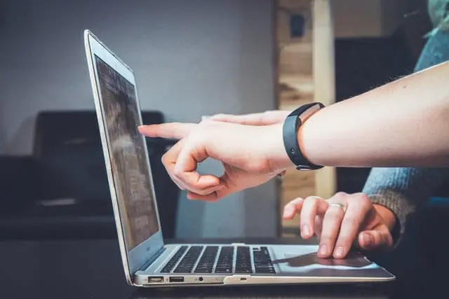 Zakupy Czarny Piątek - jak kupować, by nam się opłaciło Dłonie, wskazujące na ekran laptopa.