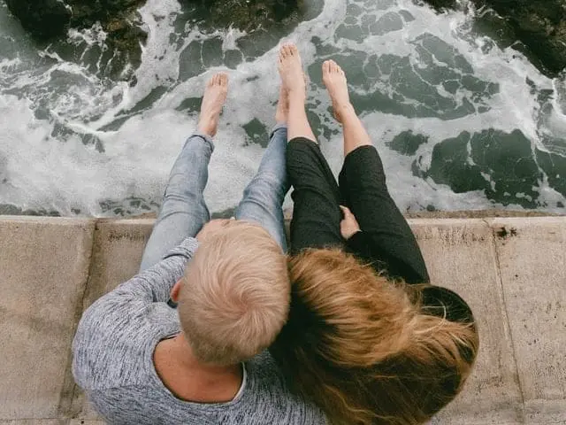 Zakochani, siedzący na brzegu oceanu. 