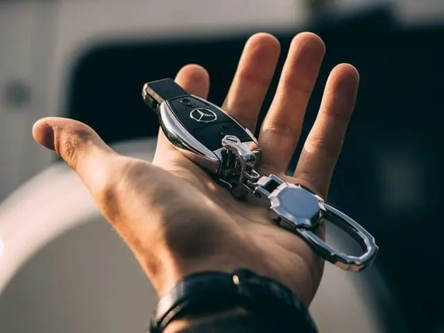 Dłoń, która trzyma pilot do samochodu. 