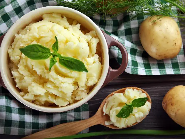 Puree ziemniaczane w miseczce i na drewnianej łyżce. 
