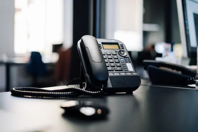 Telefon stacjonarny w czarnym kolorze. 