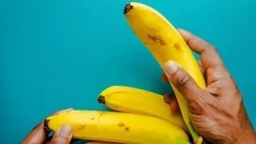Dłoń sięgająca po banana.
