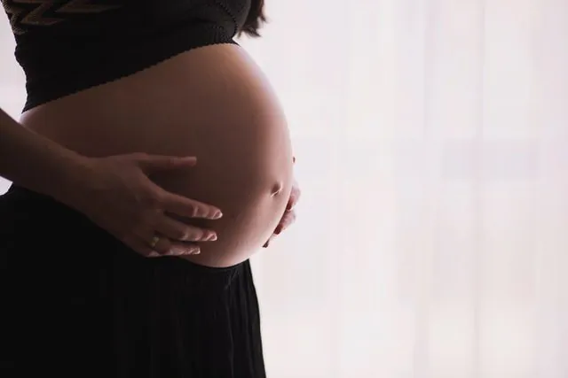 Wrzuć do wanny drożdże: zobacz po co Kobieta w ciąży obejmująca swój brzuch.