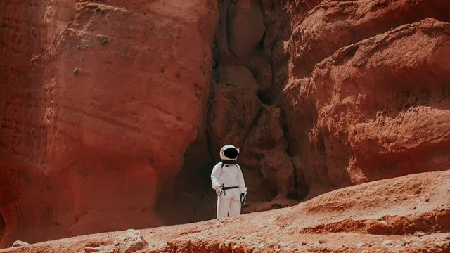 Baza na marsie z krwi i moczu Astronauta wśród czerwonych skał.