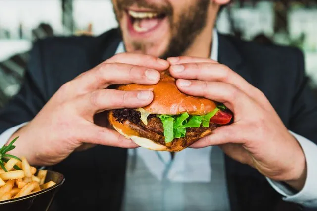 Wrzuć do wanny drożdże: zobacz po co Mężczyzna jedzący burgera.