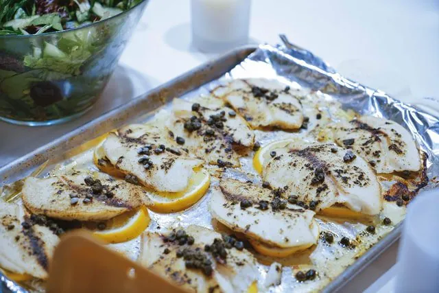 Tilapia z pieprzem i solą na blaszce do pieczenia.