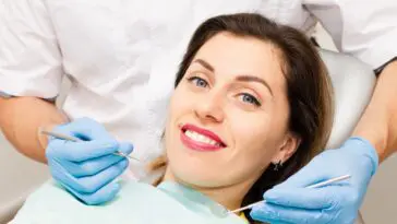 uśmiechnięta kobieta na fotelu dentystycznym