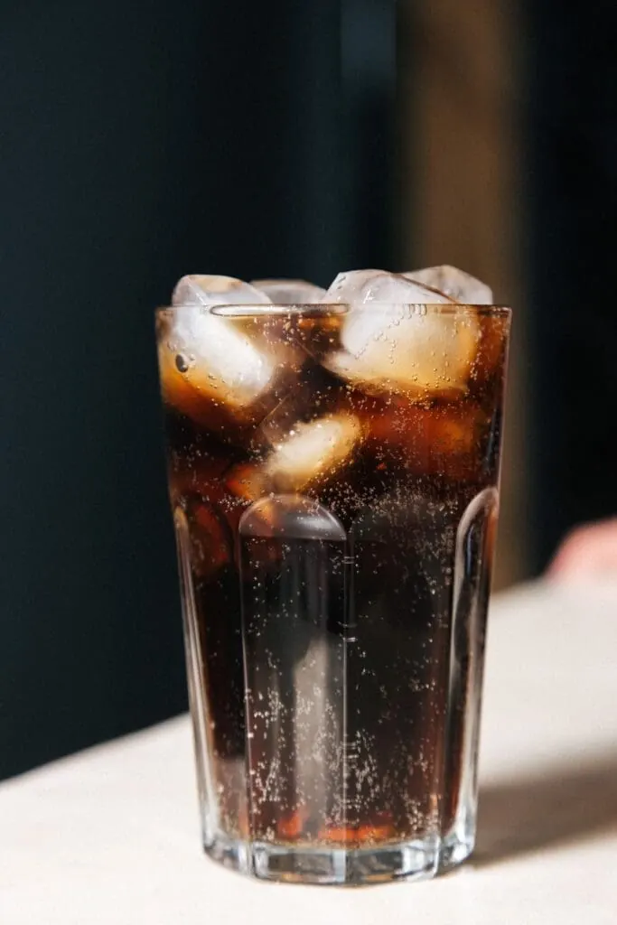 Cola z lodem, cukier w słodzonym napoju Szklanka coli z lodem: puszka słodzonego napoju to około 35 g cukru