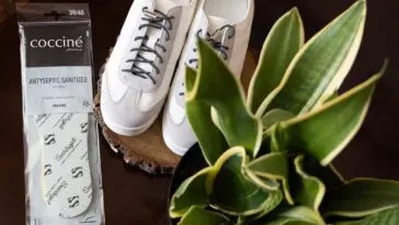 Wkładki do butów Coccine obok białych sneakersów