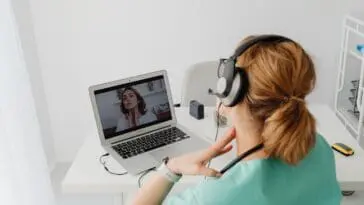 Kobieta rejestruje wizytę lekarską przez laptop korzystając z e-rejestracji NFZ