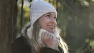 Kobieta w białej zimowej czapce na tle zimowego krajobrazu