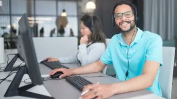Konsultanci infolinii Banku Pekao pracujący w call center przy słuchawkach