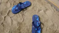 Klapki leżące na plaży, podstawowa ochrona stóp przed grzybicą na basenie i w saunie