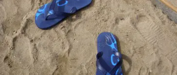 Klapki leżące na plaży, podstawowa ochrona stóp przed grzybicą na basenie i w saunie