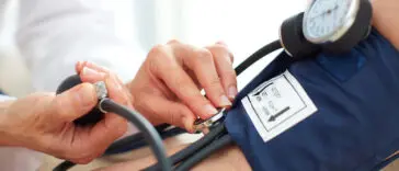 Lekarz mierzy pacjentowi ciśnienie tętnicze za pomocą ciśnieniomierza
