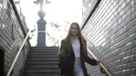 Osoba schodząca po schodach trzymająca się poręczy, profilaktyka upadków w domu