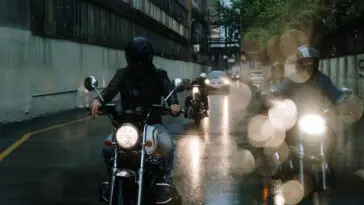 Motocyklista w kasku jadący motorem po drodze – sennik motor