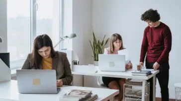Dwie osoby przy biurku w jasnym biurze typu open space podczas wspólnej pracy