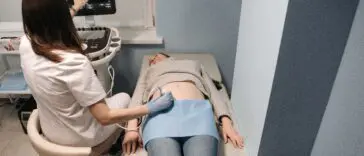 Lekarz wykonuje badanie USG tarczycy u pacjentki