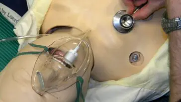 Lekarz osłuchuje płuca pacjenta stetoskopem podczas diagnostyki zapalenia płuc