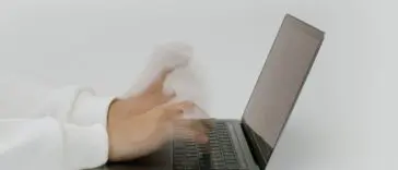Dłonie wpisujące hasło na klawiaturze laptopa