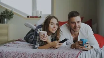 Para ogląda film w domu podczas wieczoru filmowego
