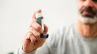 Mężczyzna korzystający z inhalatora, objawy POChP i trudności w oddychaniu