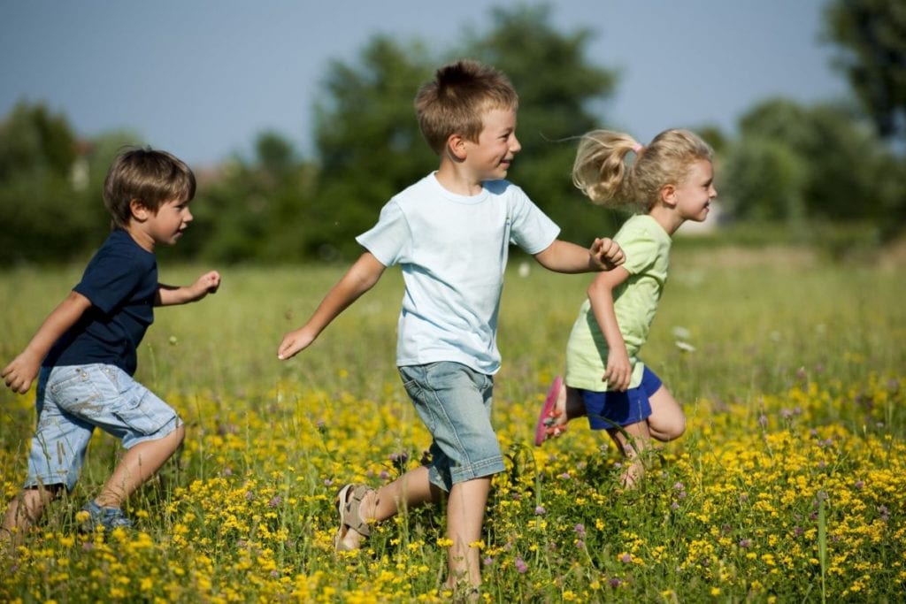 dzieci biegające po łące
