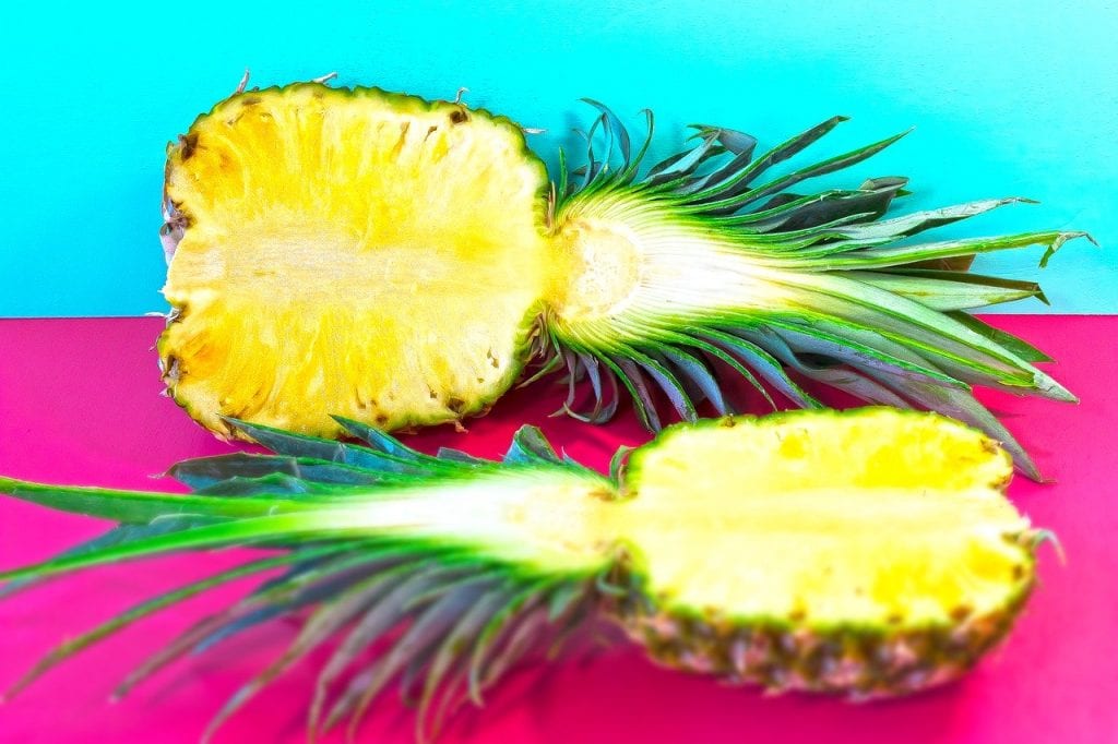 15 zdrowotnych właściwości ananasa dwie połówki ananas na kolorowym tle