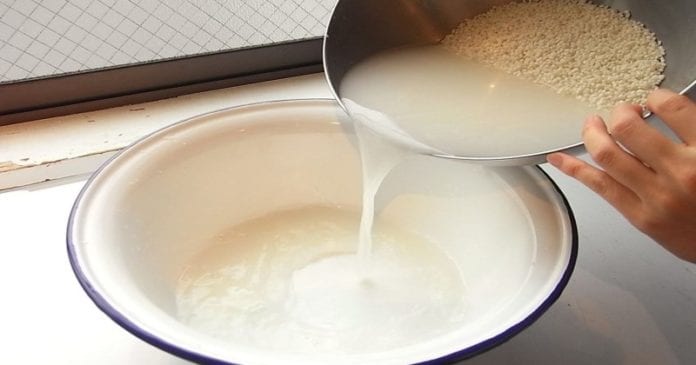 Przelewanie wody z ryżu do innego naczynia. 