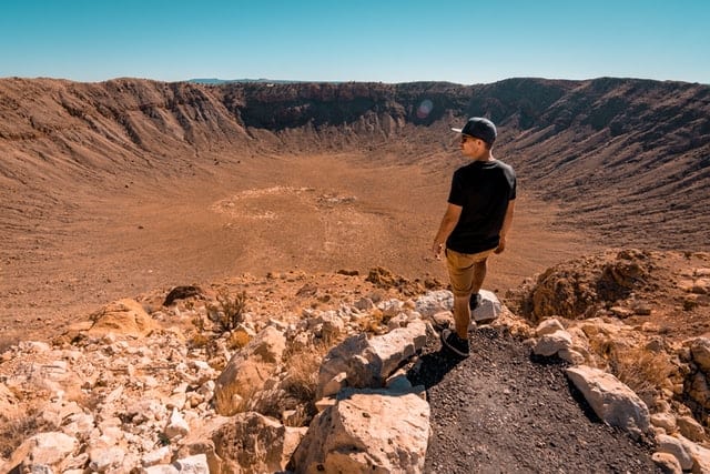 Mężczyzna, stojący nad kraterem. 