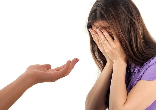 Najpopularniejsze nurty psychologiczne w terapii Dłoń wyciągnięta w kierunku płaczącej dziewczynki.