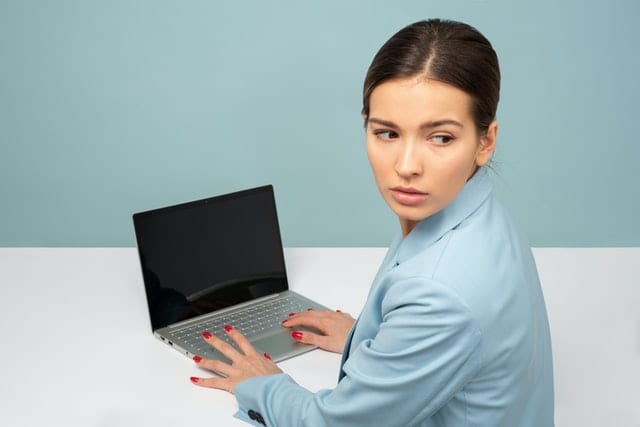 Przestraszona kobieta przed komputerem. 