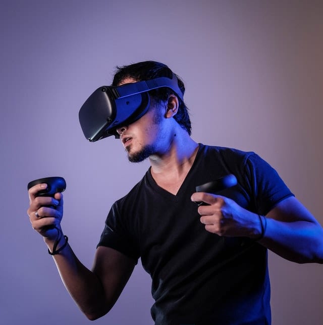 Młody mężczyzna z kontrolerami w rękach i okularami VR. 