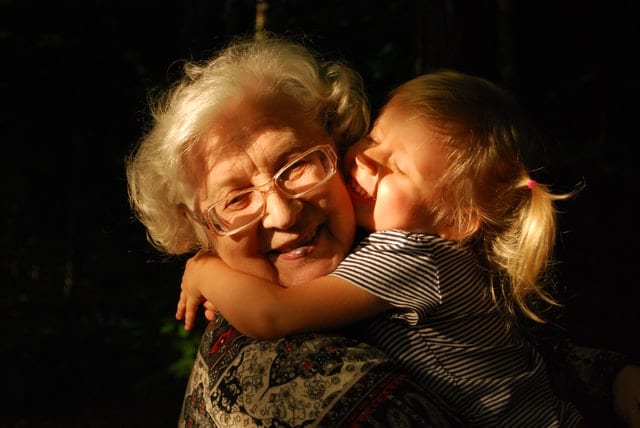Starsza kobieta przytulająca wnuczkę.
