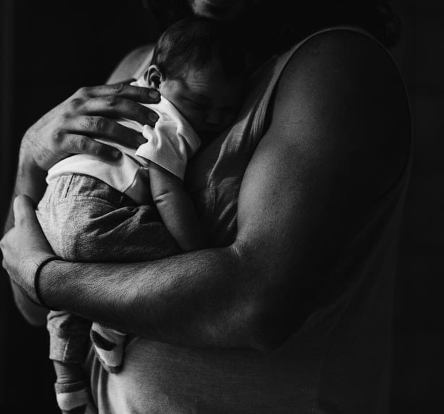 Mężczyzna trzymający dziecko na rękach. 