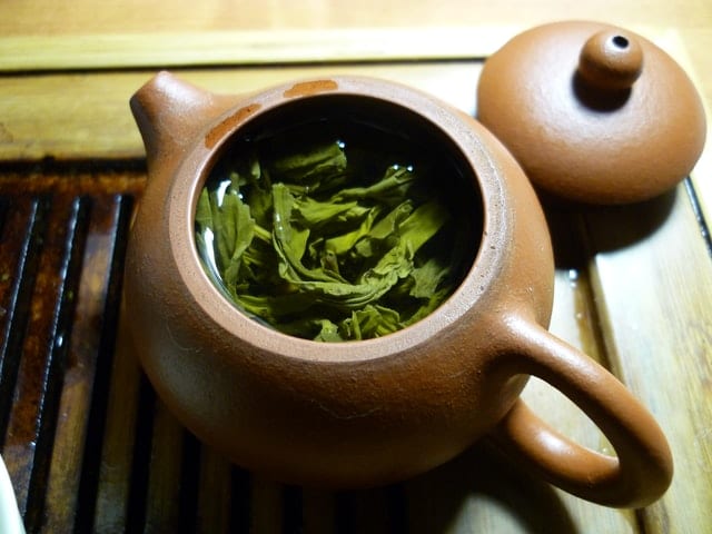 Zielona herbatka w glinianym dzbanku.