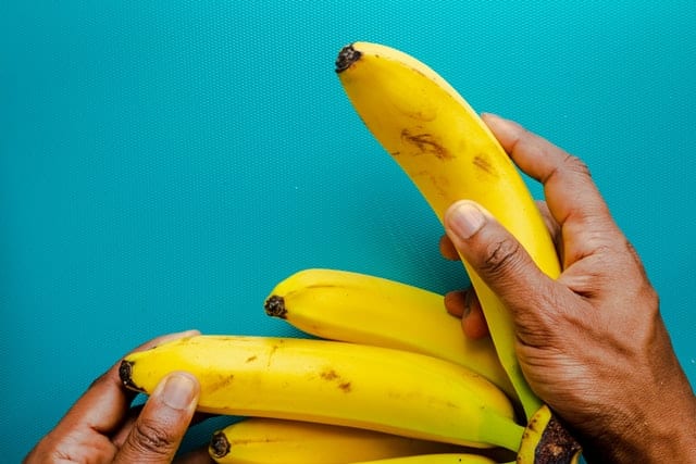 Dłoń sięgająca po banana.