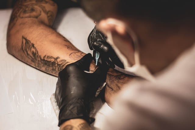 Mężczyzna wykonujący tatuaż. 