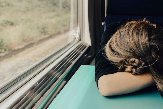 Młoda kobieta śpiąca w pociągu. 