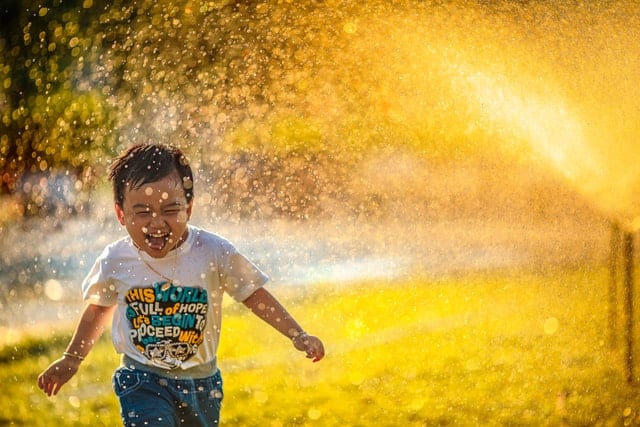 Dziecko bawiące się w wodzie słonecznego dnia.