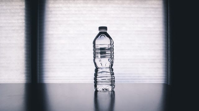 10 porad jak przetrwać upały Butelka na stole.