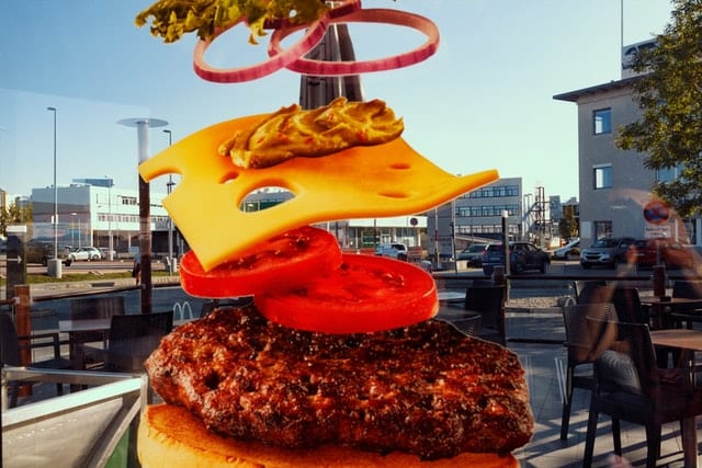 Sztuczki fotografów reklamowych Składniki opadające na mięso z burgera.