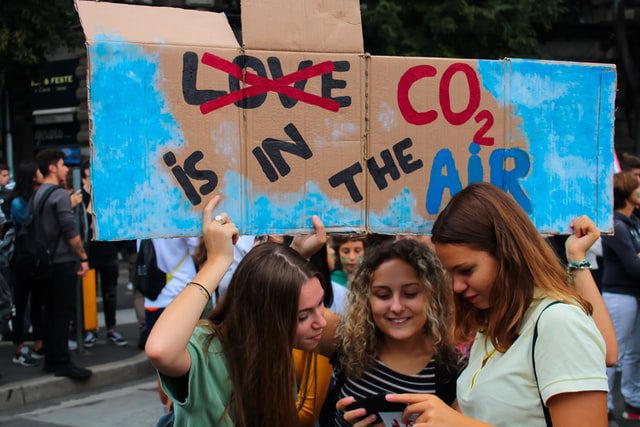 Dziewczyny trzymające transparent z napisem 'co2 jest w powietrzu'.