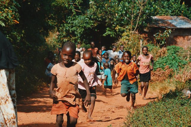 Czarnoskóre dzieci biegnące ścieżką.