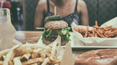 Burger i frytki na stole.